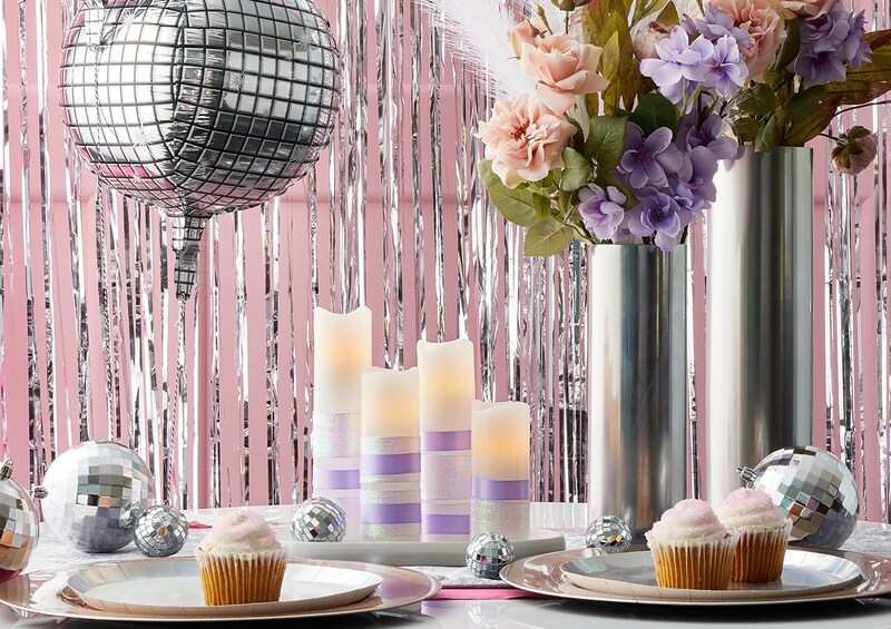 Pastel party decor sitting on table with a couple cupcakes